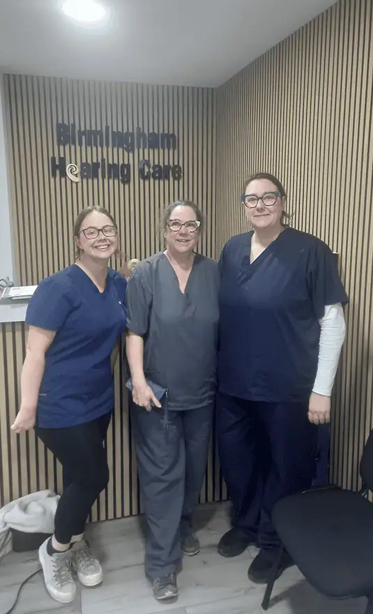 Birmingham Hearing Care audiologists team in scrubs standing together in reception.